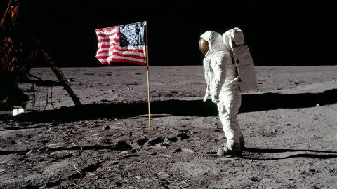 Astronaut met Amerikaanse vlag op de maan.
